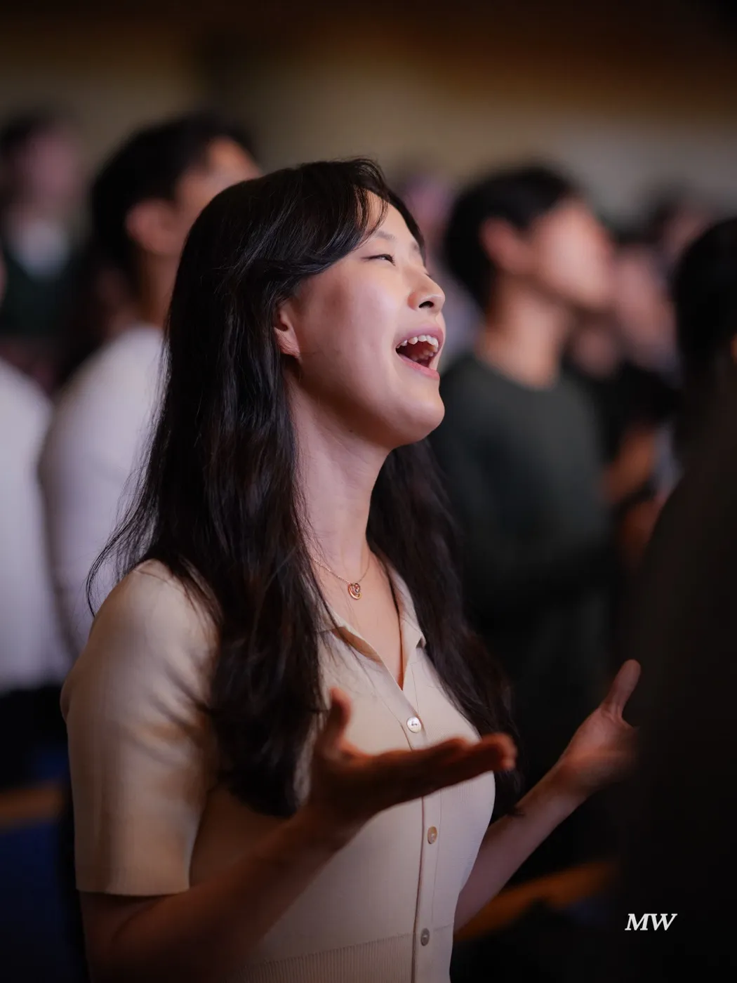 A worshiper singing with open hands and closed eyes