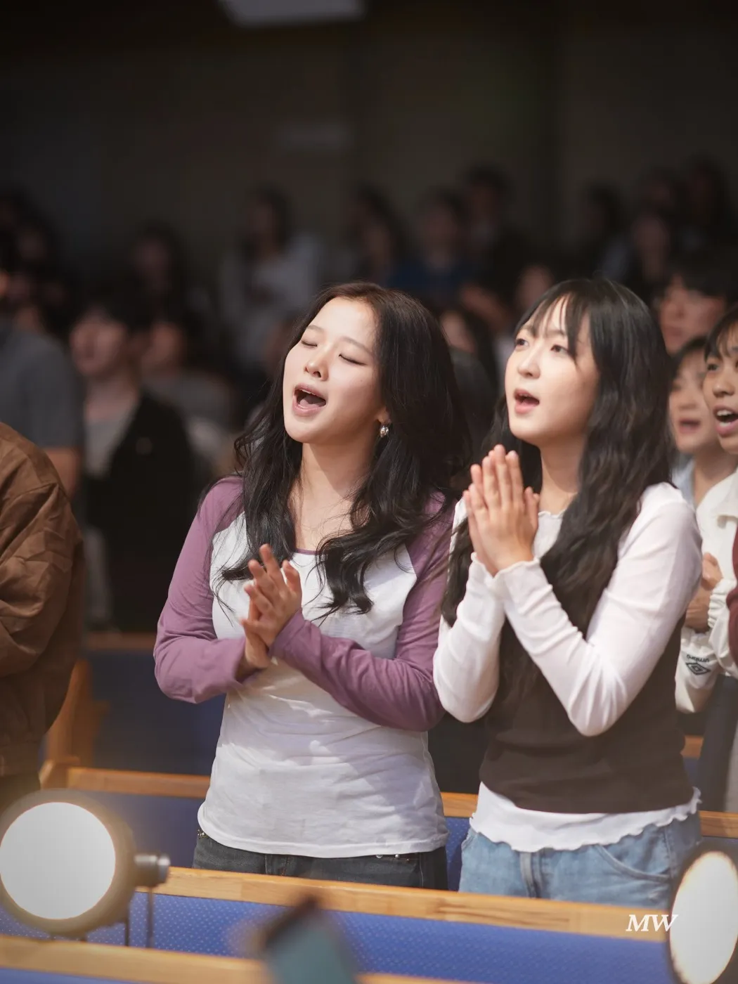 Worshipers singing together with hands clasped