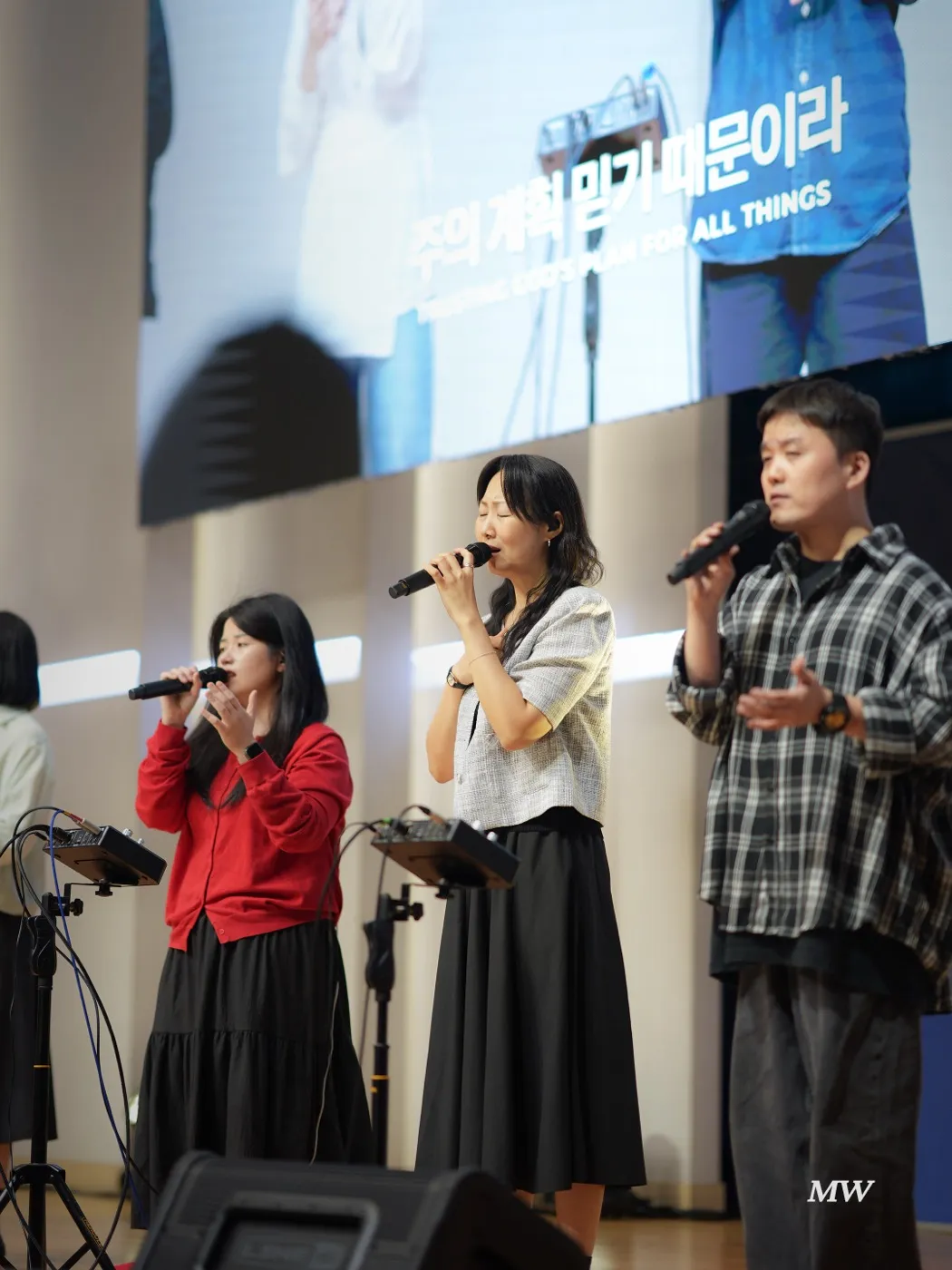 The worship team singing on stage, with lyrics on the screen