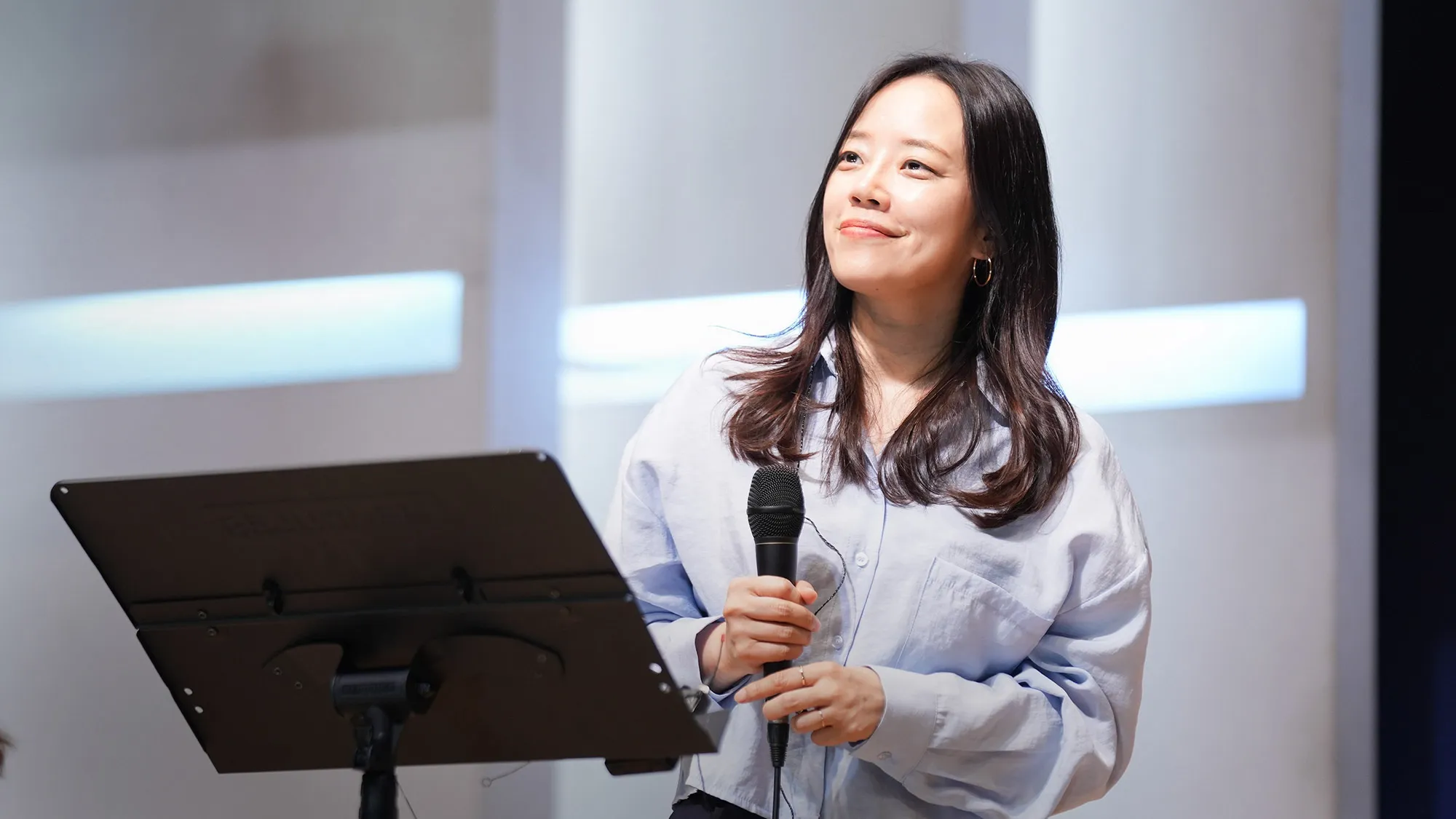 A worship leader and vocalists singing together