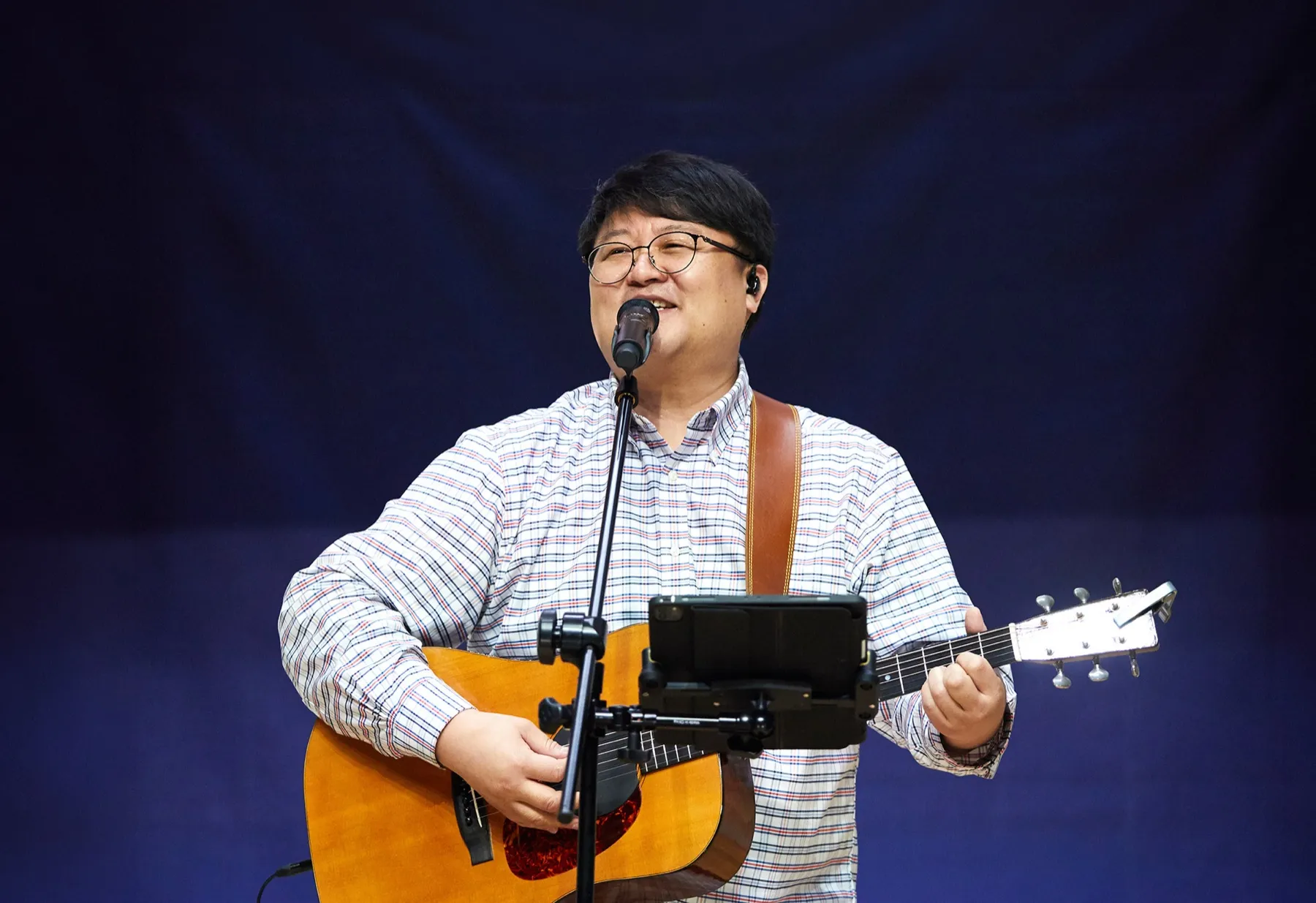 Worship leader Shim Jongho singing with a guitar